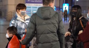 varianti covid, Persone con mascherine a Wuhan per epidemia da Coronavirus