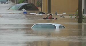Alluvione in Romagna, Un uomo avanza nell'acqua a Cesena